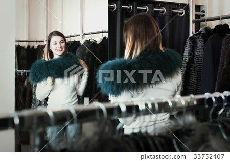 Pretty woman customer examining new fur neckpiece 33752407