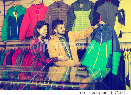 Couple examining windcheaters in store 33753811