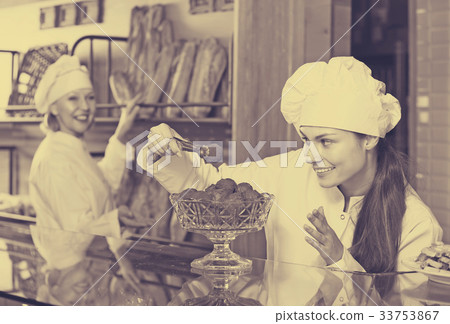 Cafe staff offering cakes 33753867