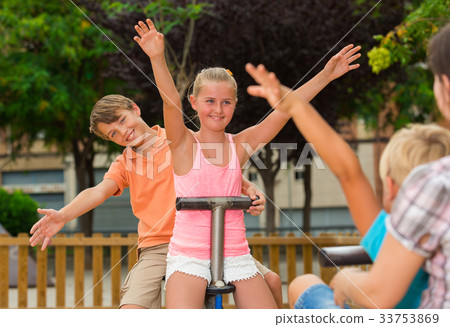 图库照片: cheerful children are teetering on the swing