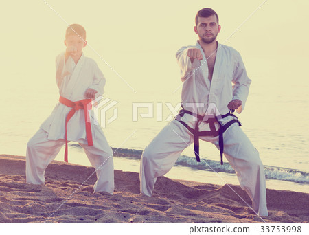 Teacher and boy doing karate poses 33753998