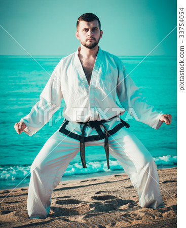 Guy practising karate at seaside 33754054