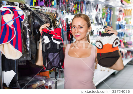 Female customer choosing clothes for dog Female customer choosing clothes for dog 33754056
