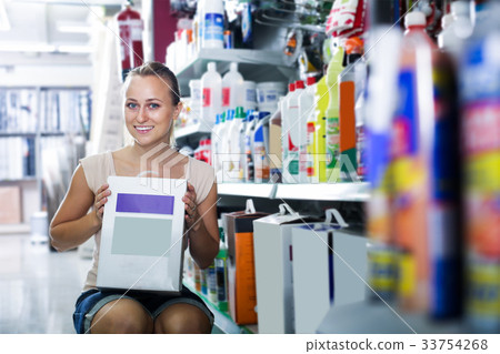 cheerful woman customer holding box with dry filler in hypermarket 33754268