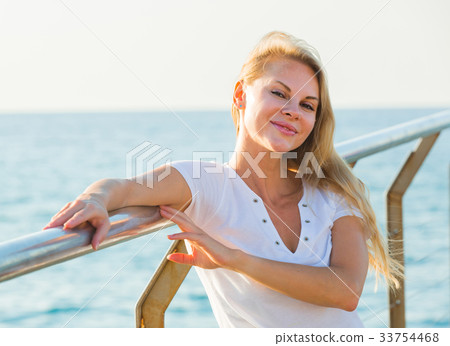Cheerful female is posing playfully on pirce in her free time Cheerful female is posing playfully on pirce in her free time 33754468
