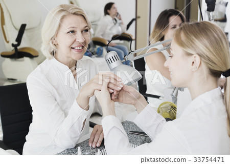 Happy women doing manicure Happy women doing manicure 33754471