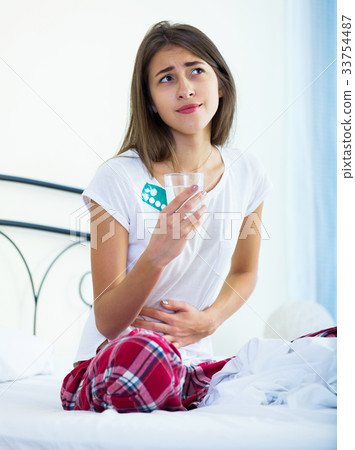 Teenage girl having belly pain and taking pills Teenage girl having belly pain and taking pills 33754487