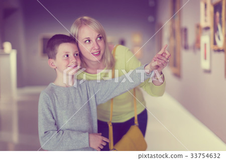 Smiling mom and son exploring paintings 33754632