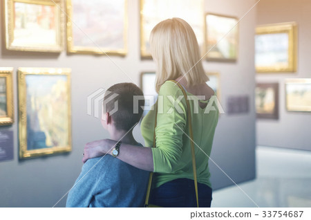 Mother and son looking at paintings in halls of museum 33754687