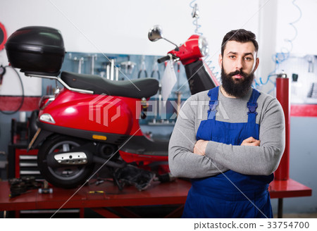 Male worker demonstrating motorbikes and scooters Male worker demonstrating motorbikes and scooters 33754700