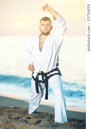 Glad male doing karate at ocean quay 33754859