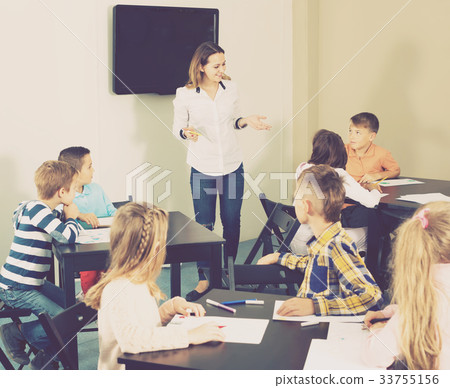 Little cheerful children with teacher drawing in classroom 33755156