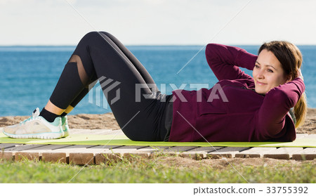 Ordinary girl exercising on exercise mat 33755392