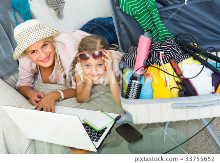 Woman with daughter planning vacation. 33755652