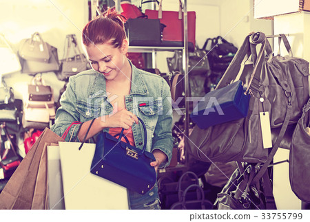 Girl buying handbag in fashion shop 33755799