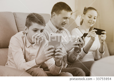 Parents and son using phones Parents and son using phones 33755954