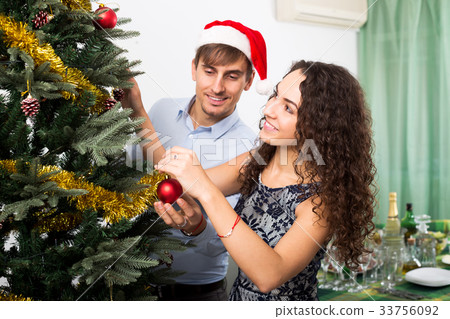 Couple decorating Christmas tree Couple decorating Christmas tree 33756092