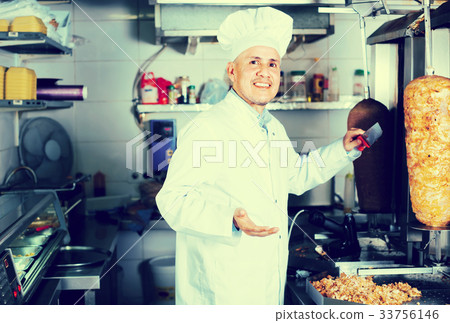 mature chef slicing kebab in fast food. mature chef slicing kebab in fast food. 33756146