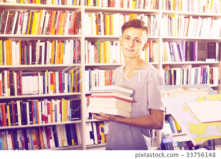 Teenager holding pile of books Teenager holding pile of books 33756148