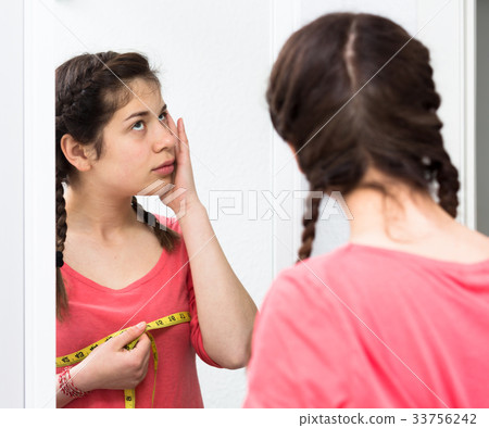 Girl sad measuring breast 33756242