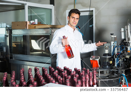 man employee standing in final section of wine production on factory 33756487