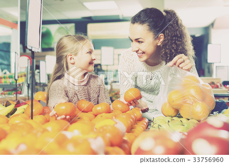 Ordinary mother and daughter buying ripe fruits 33756960