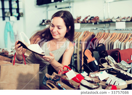 woman selecting shoes in footgear center. woman selecting shoes in footgear center. 33757086
