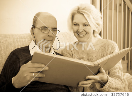 Couple sitting with photograph album 33757646
