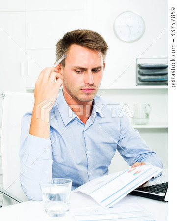 Man sitting at working and having work troubles 33757859