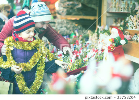 Girl with father buying decorations for Xmas 33758204