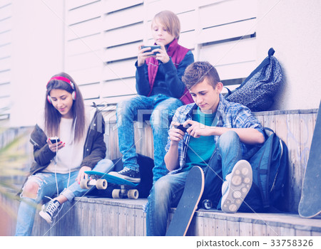 Three teenagers with smartphones 33758326