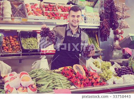 glad male seller showing assortment of grocery shop glad male seller showing assortment of grocery shop 33758443