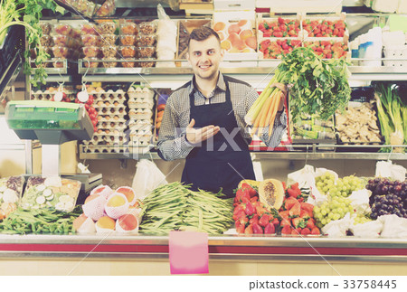 Man seller 20-29 years old is displaying assortment Man seller 20-29 years old is displaying assortment 33758445