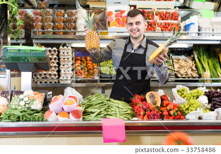 Guy shop assistant is displaying assortment Guy shop assistant is displaying assortment 33758486