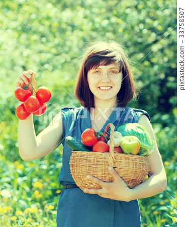 Happy woman with basket of harvested vegetables Happy woman with basket of harvested vegetables 33758507