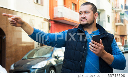 Man on street with phone Man on street with phone 33758508