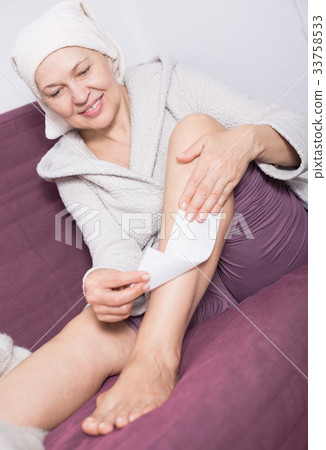 Woman doing body hair removal 33758533