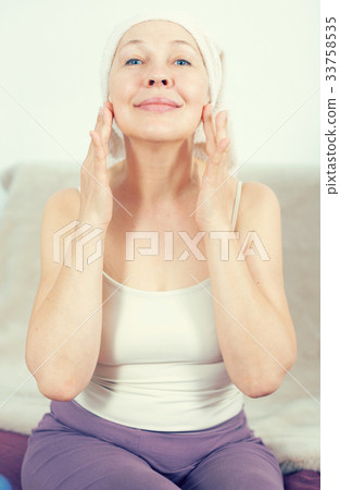 Woman using face cream Woman using face cream 33758535