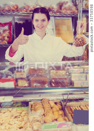 Seller in white uniform with dark cookies Seller in white uniform with dark cookies 33758598