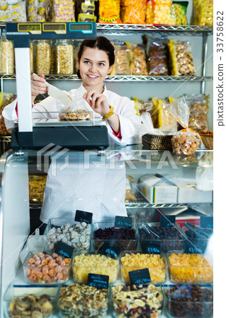 Girl in uniform selling candied fruits and nuts 33758622