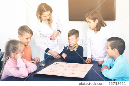 Children making move on pre-marked surface of board game 33758631