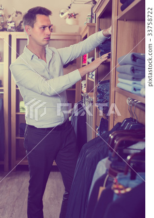 Male is choosing on new pants 33758722
