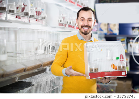Positive man enjoying his purchase of canary bird 33758743