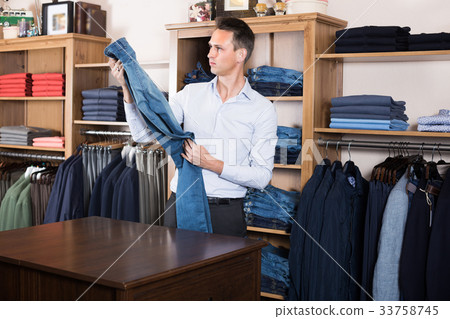 Guy is deciding on for new jeans 33758745