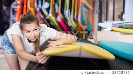 Portrait of smilling girl who is choosing surfboard Portrait of smilling girl who is choosing surfboard 33758785