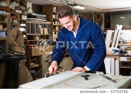 guy using chisel to process plank at workshop guy using chisel to process plank at workshop 33758786