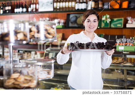 Seller offering tray of cakes Seller offering tray of cakes 33758871