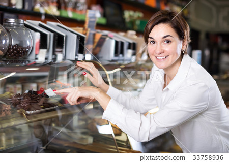 Happy female client choosing delicious dessert Happy female client choosing delicious dessert 33758936