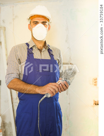 Positive worker repairer standing with electric saw Positive worker repairer standing with electric saw 33759184