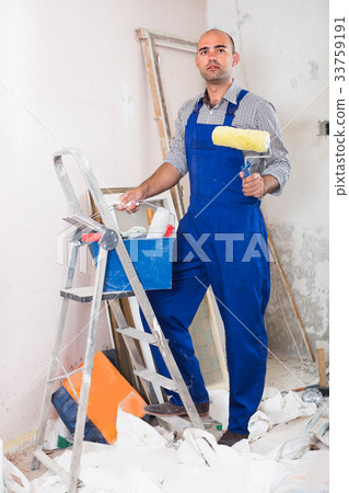 Repairer is standing with roller in uniform Repairer is standing with roller in uniform 33759191